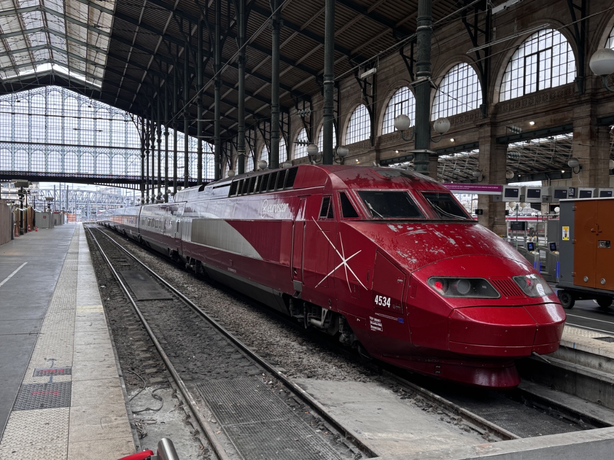 Red high-speed train at historic station