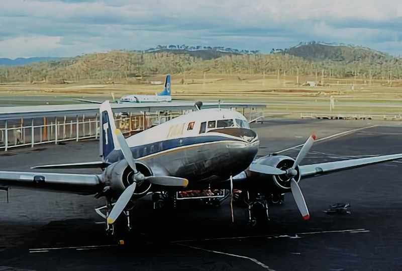 Vintage twin-prop airplane parked on tarmac